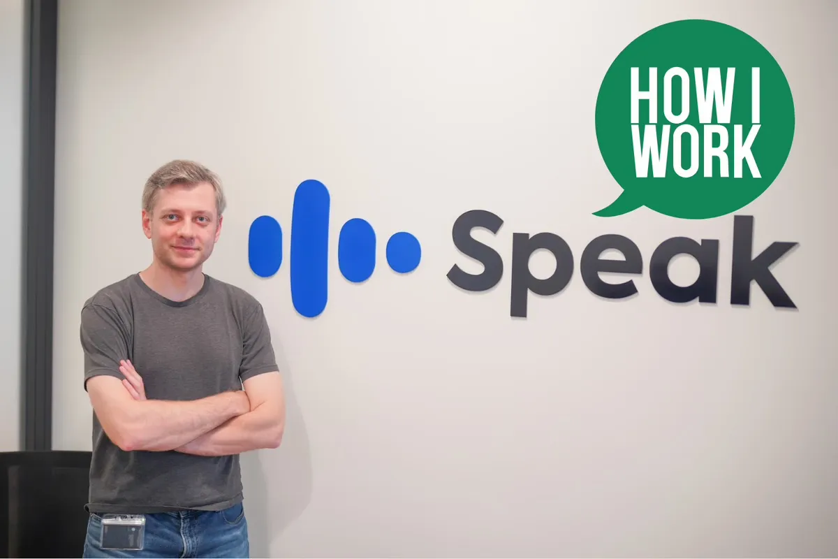Yan standing in front of the Speak logo for the How I Work interview
